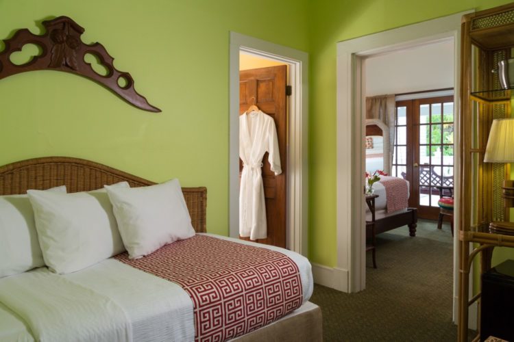 Lime green bedroom with twin bed with connecting bathroom with a separate sitting room connected to patio