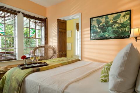 Peach room with panda painting on wall facing windows with mini blinds and connecting yellow bathroom