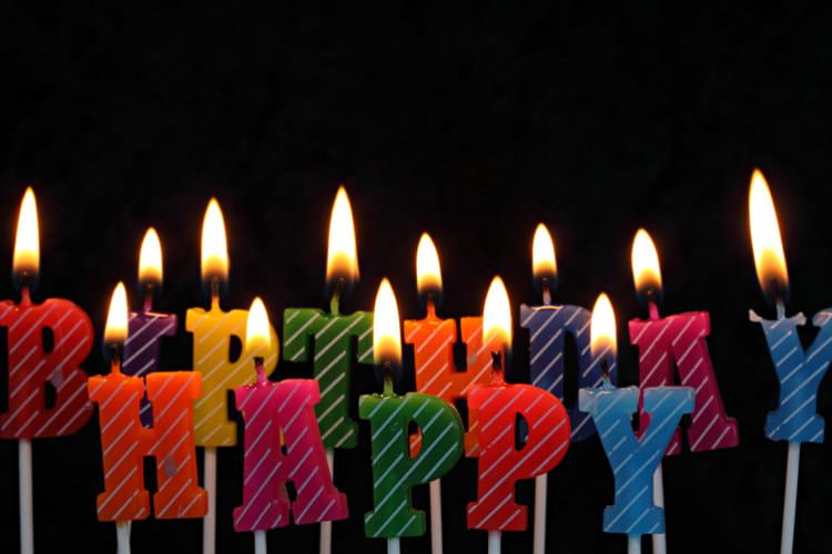 Variety of colored lit candles spelling out Happy Birthday
